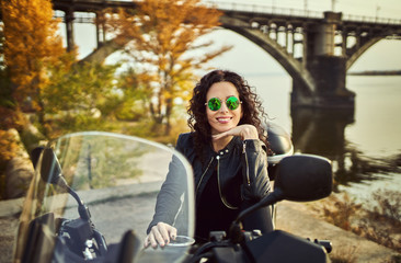 Fototapeta na wymiar Young woman resting sitting on a motorcycle . Travel and tourism concept