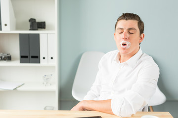 Obraz premium Joke, humor, office, people concept - man chewing the gum while he is working, gum splitted