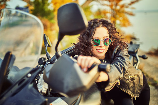 Young woman resting sitting on a motorcycle . Travel and tourism concept
