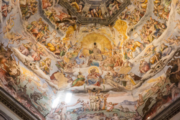 Fototapeta na wymiar Florence, Italy July 3rd, 2015: Looking up at the stunning artwork inside the dome of the duomo in Florence, Italy