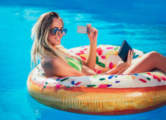 Summer Vacation. Enjoying suntan Woman in bikini on the inflatable mattress in the swimming pool...