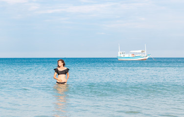 beautiful girl standing waist-high in the sea