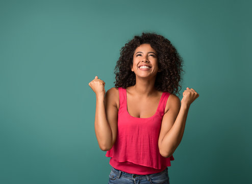 Happy Woman Celebrating Her Success On Blue Background