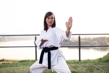 Young woman in  kimono practicing her karate moves.