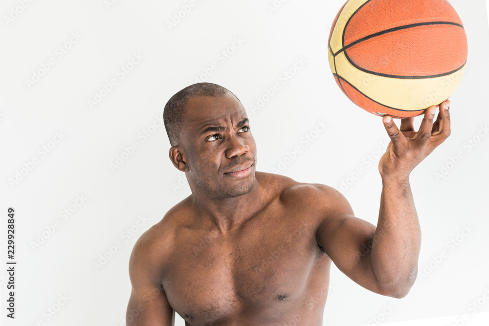 Poster muscular afro american athlete with basketball ball on white background