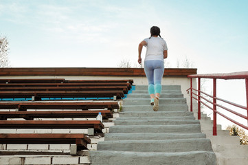Active girl with excess weight is going to the sports to lose weight at the stadium. Healthy lifestyle.