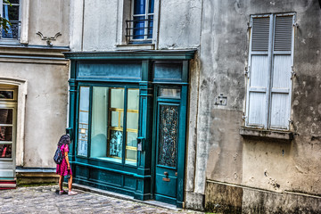 Fototapeta na wymiar Girl watching a store window in Montmartre