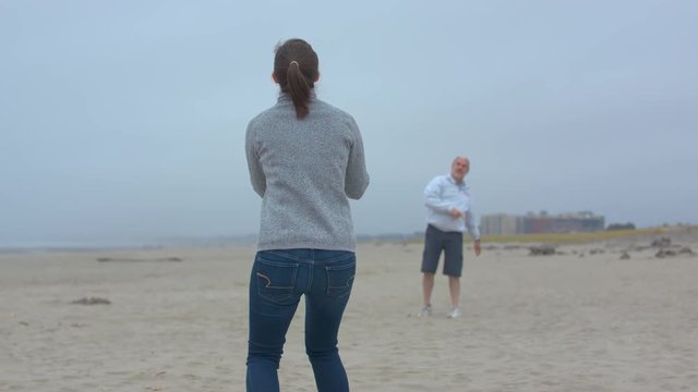 Daughter Catching A Football Thrown By Her Father