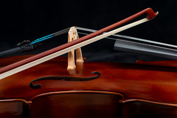 Fototapeta na wymiar Close up of a cello and a bow set against a black background