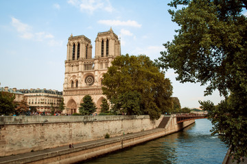View of the beautiful building of Notre Dame de Paris with trees. On a sunny day