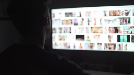 Young mand watching naked women in the computer screen