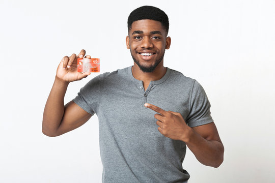 Cheerful african-american man pointing at credit card