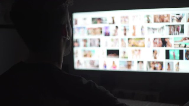 Young mand watching naked women in the computer screen