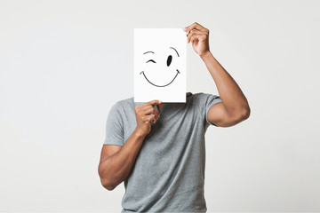 Black man holding paper with smiley face