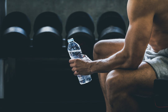 Fitness Man Drinking Water In Gym