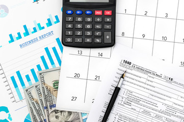Naklejka na ściany i meble Tax form with calendar on financial graphs.