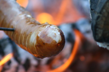 Grilled sausages over the fire. Evening with friends