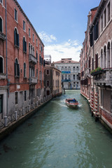 Fototapeta na wymiar Boot fährt durch Venedig Kanal 