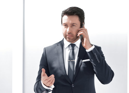 serious businessman talking on mobile phone