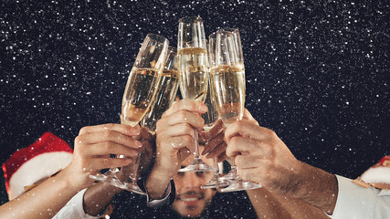 Clinking glasses of champagne in hands at New Year party