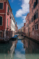 Fototapeta na wymiar Blick auf Kanal und Brücke in Venedig Wolken spiegeln sich in Wasser