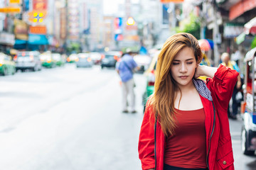 Asian white-haired girl wearing a red long-sleeved dress with a cap Using the left hand to catch the neck. Because of the pain after shoulder bag.