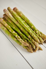 Above view of flat-lay organic raw uncooked green asparagus placed on rustic wooden table background, Close up.