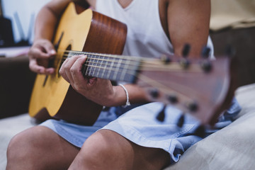 man's hands playing acoustic guitar, close up