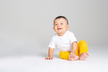 funny baby boy sitting on white background