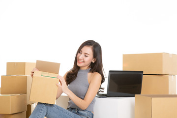 Young woman freelancer working and checklist and writing order with cardboard box on white background - SME business online and delivery concept