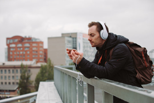 Man in headphones listening to music outdoors in city