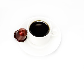 White cup with coffee capsule on white background.