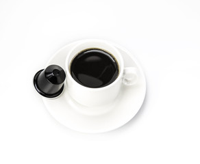  White cup with coffee capsule on white background.