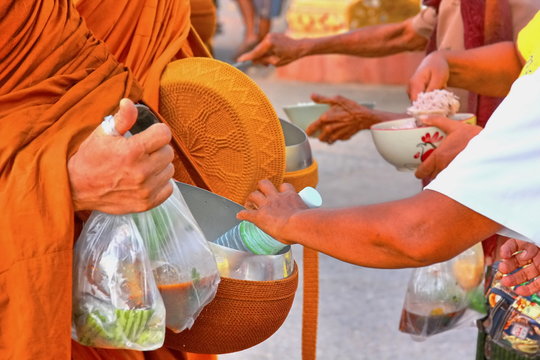 monk reciving food and many things from poeple. it is south east Asia culture