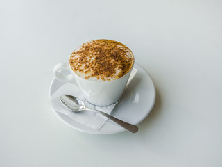White Cup of cappuccino on a white table.
