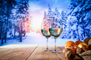 Two glasses with white wine on an old wooden table in a Christmas mood  