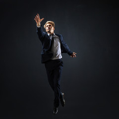 Businessman jumping up. Young man in business suit seeking higher