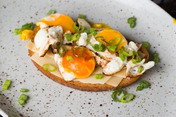 Toast with fried egg on plate.