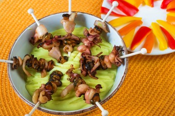 Skewers with seafood mix in bowl,sliced pepper on plate.