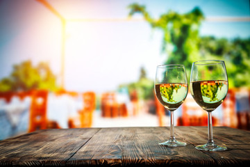 Two glasses with wine on a wooden table in an autumn setting   