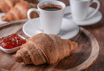 croissant with coffee and jam made of cherry and apricot. Put on a stand tree