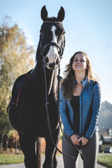 Obraz premium Junge schöne Frau und schwarzes Pferd Ausritt, reiten, Derssur, Reiterin