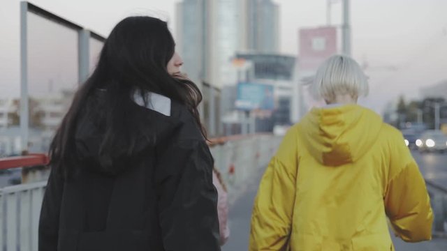 Three women walking down a street