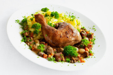 chicken stewed in red wine with vegetables, forest mushrooms, and brisket served with gravy sauce, garnished with potato, and decorated with parsley