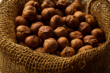 Close up image of a handful of raw hazelnuts in textile bag. Baking ingredient concept