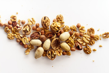 Overhead image of a group of various nuts with nutshells isolated on white background with copy space