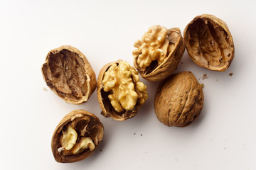 Raw walnuts with cracked nutshells on white background isolated with copy space
