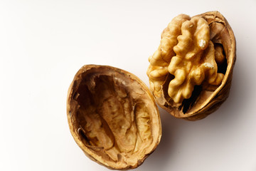 Obraz premium Raw walnuts with cracked nutshells on white background isolated with copy space