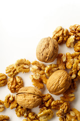 Top view of a heap of raw walnuts with a nutshell on white background isolated with copy space