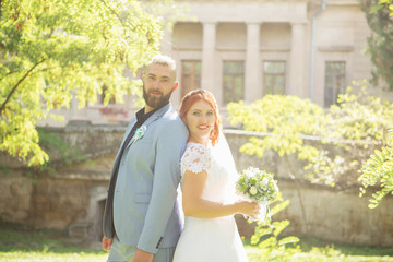 Just married loving hipster couple in wedding dress and suit in the park. Happy bride and groom walking running and dancing. Romantic Married young family.